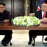 U.S. President Donald Trump and North Korea\'s leader Kim Jong Un hold a signing ceremony after their first meeting in Singapore on June 12. A South Korean newspaper reported Japan is ready to host a second U.S.-North Korea summit meeting. | REUTERS