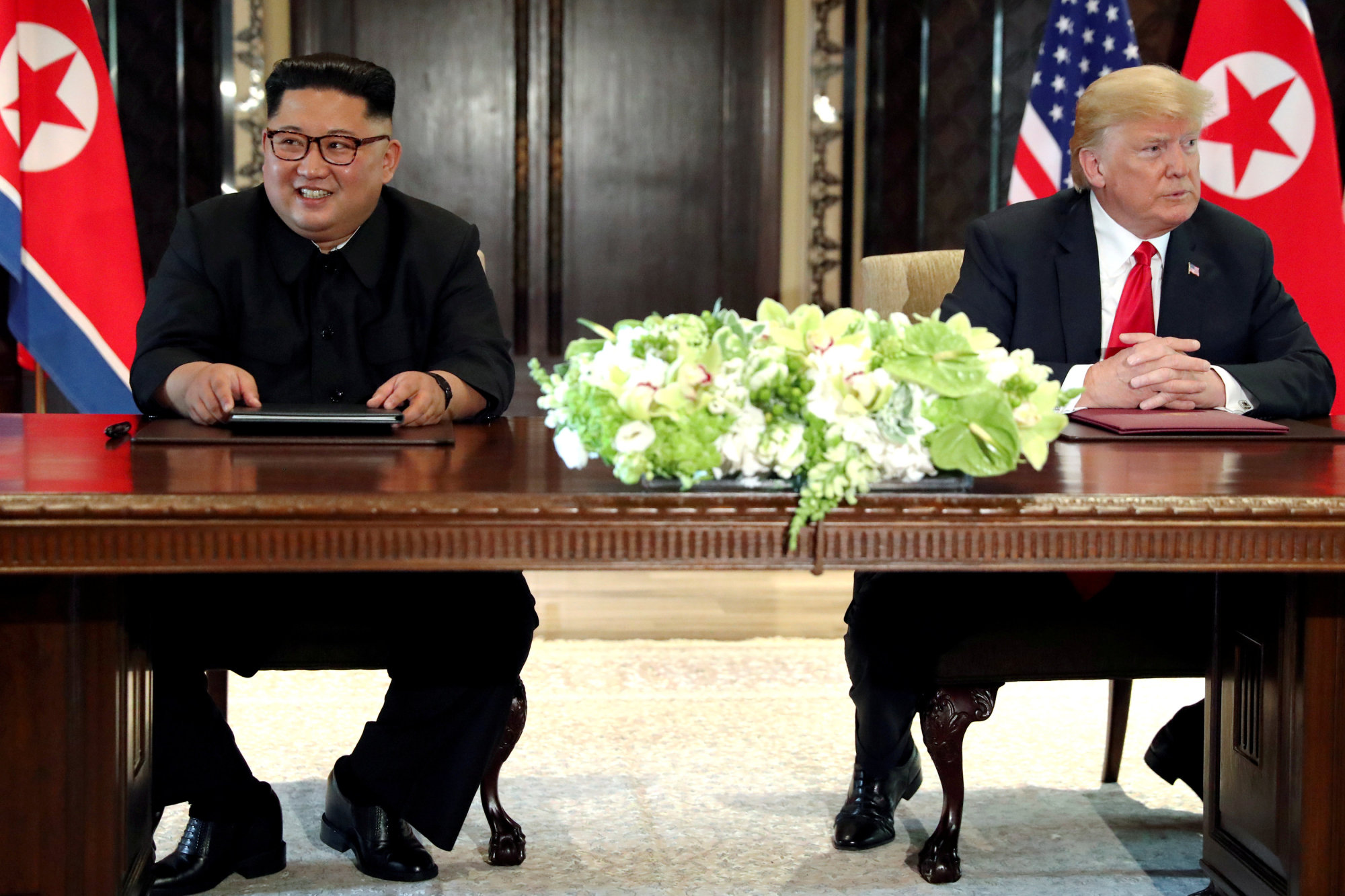 U.S. President Donald Trump and North Korea's leader Kim Jong Un hold a signing ceremony after their first meeting in Singapore on June 12. A South Korean newspaper reported Japan is ready to host a second U.S.-North Korea summit meeting. | REUTERS