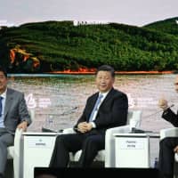 Prime Minister Shinzo Abe and Chinese President Xi Jinping listen as Russian President Vladimir Putin speaks at the Eastern Economic Forum in Vladivostok on Sept. 12. Abe and Xi held a summit that day and will meet again in Beijing on Friday. | BLOOMBERG