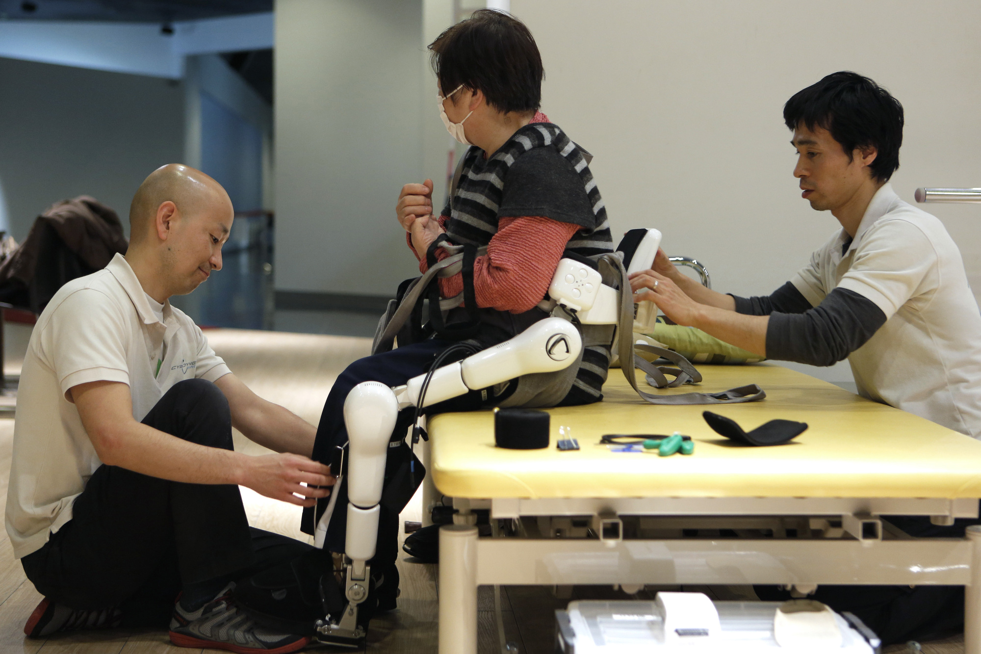 Helping hardware: Physical therapists fit an elderly woman with paralysis on her left side with the lower limb model of Cyberdyne Inc.'s Hybrid Assistive Limb (HAL) robot suit in Tsukuba, Ibaraki Prefecture. | BLOOMBERG