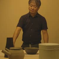 Naoto Fukazawa selects exhibits in a film by Noriaki Okamoto. | REUTERS
