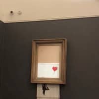 Banksy\'s painting \"Girl with Red Balloon\" is seen shredded after its sale at Sotheby\'s auction in London on Oct. 5. | REUTERS