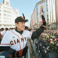 Giants manager Tatsunori Hara waves to fans during a victory parade held after the club won the 2012 Central League and Japan Series titles. | KYODO