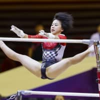 Mai Murakami competes in the uneven bars portion of the women’s all-around team event at the World Artistic Gymnastic Championships in Doha on Tuesday. | KYODO