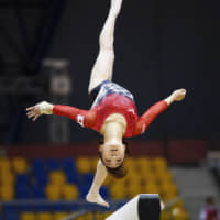 Asuka Teramoto leaps on the balance bar during the world championships. | KYODO