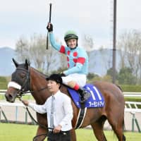 Christophe Lemaire waves from Almond Eye after winning the Shuka-sho on Sunday. | KYODO