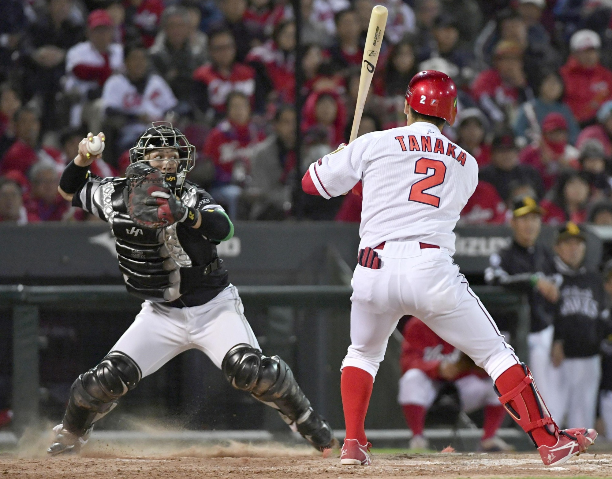 Hawks catcher Takuya Kai throws out Carp base runner Takashi Uemoto at second base to end the ninth inning as Kosuke Tanaka looks on from the batter's box in Game 1 of the Japan Series on Saturday at Mazda Stadium. | KYODO