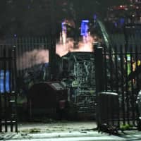 Smoke rises from the wreckage of a helicopter that crashed in a parking lot outside Leicester\'s King Power Stadium on Saturday night. | AFP-JIJI