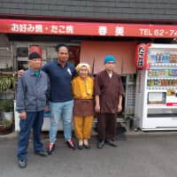 Harumi Okuno (second from right) and husband Hiroshi (left) pose with retired player Toetu\'u Taufa outside their restaurant in Higashiosaka. | ANDREW MCKIRDY
