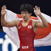 Takuto Otoguro celebrates his victory over Bajrang Punia of India in the final of the 65-kg freestyle class at the World Wrestling Championships in Budapest on Monday. | AP
