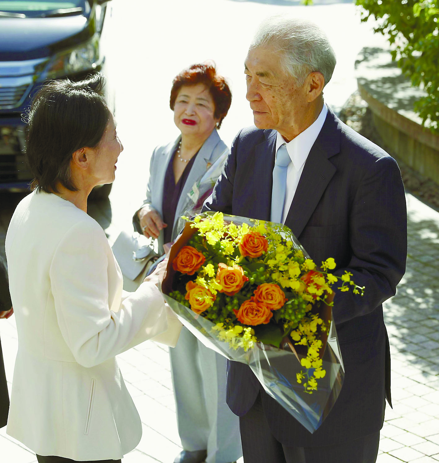 Tasuku Honjo, a professor at Kyoto University who jointly won this year’s Nobel Prize in medicine, receives flowers at the university Tuesday morning accompanied by his wife, Shigeko.  | KYODO