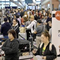 People wait in the crowded departures lobby of the international terminal at Kansai airport in Osaka Prefecture on Monday after Typhoon Trami passed through the region.  | KYODO