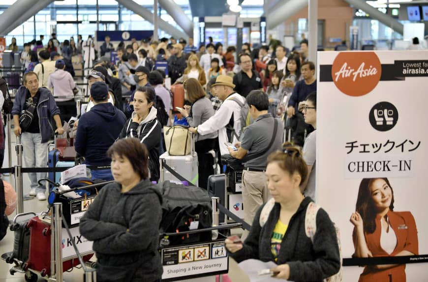 People wait in the crowded departures lobby of the international terminal at Kansai airport in Osaka Prefecture on Monday after Typhoon Trami passed through the region. 