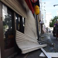 Storefront shutters are seen damaged in Tokyo\'s Suginami Ward on Monday after Typhoon Trami brought strong winds to the Kanto area.  | SATOKO KAWASAKI
