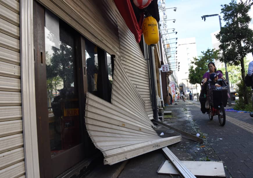 Storefront shutters are seen damaged in Tokyo