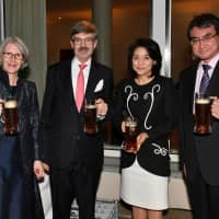 German Ambassador Hans Carl von Werthern (second from left) and his wife, Elizabeth (left), raise glasses for a toast with Foreign Minister Taro Kono (right), and his wife, Kaori (second from right), during a reception celebrating Germany\'s Unity Day at the von Werthern residence in Tokyo on Oct. 3. | YOSHIAKI MIURA