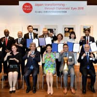 Honorary President Princess Takamado (center, front row) at Roppongi Hills on Oct. 10, with, from left, Thai Ambassador and Chairperson of the Executive Committee Bansarn Bunnag; Jana Ontkova; Hirofumi Nakasone; Timothy J. R. Mortel; Ecuador Ambassador Jaime Barberis and winner of the Ambassador Prize; and Chief of Protocol, Ministry of Foreign Affairs and executive committee member Kiminori Iwama; with jury special mentions and committee members (back row) of the &#34;Meiji 150 years, Japan transforming &#8212; Through Diplomats\' Eyes 2018\'&#34; exhibition. | YOSHIAKI MIURA