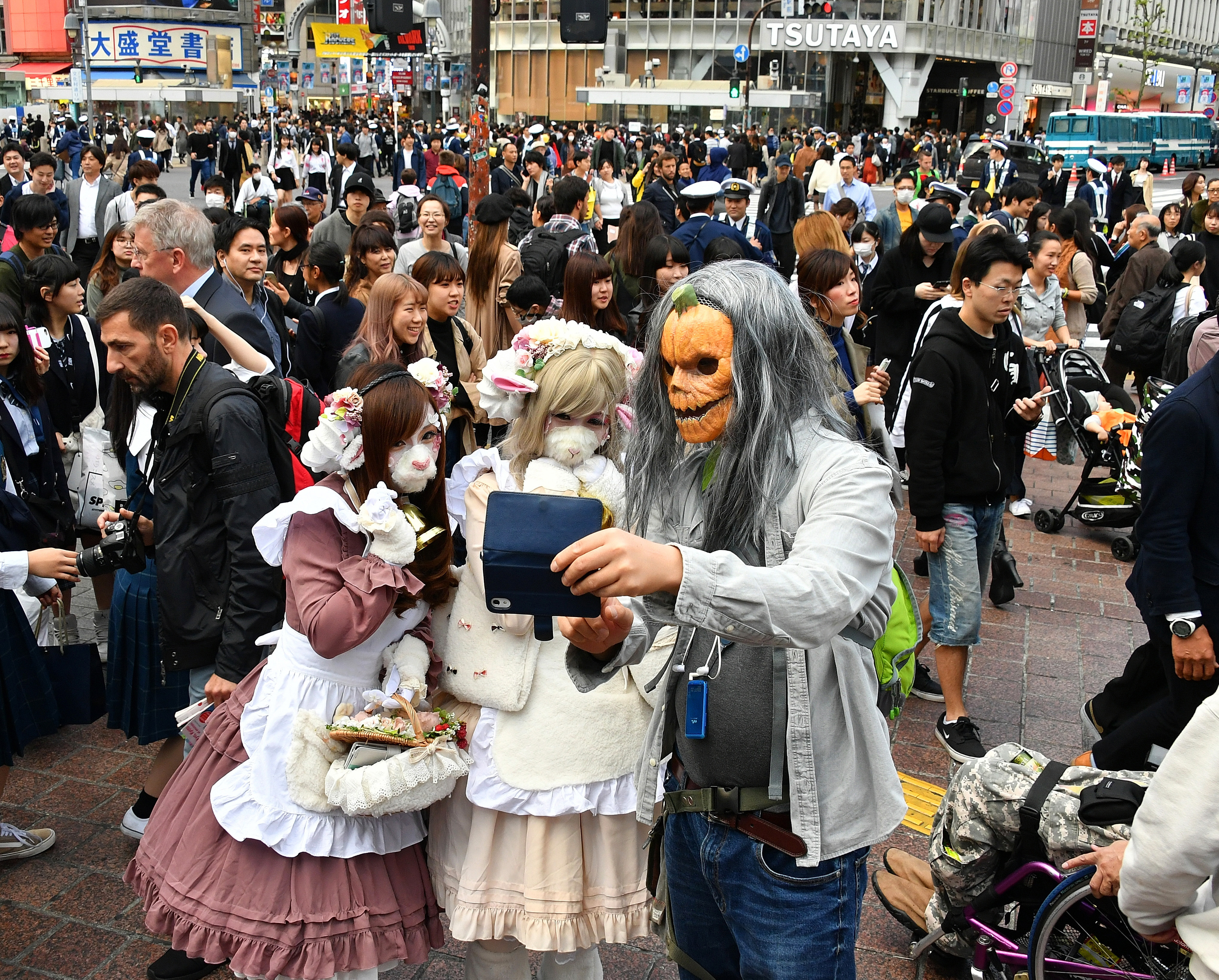 Revelers dressed up for Halloween take a selfie at the famed scramble crossing outside Shibuya Station in central Tokyo on Wednesday, the climax of the annual event. Hundreds of police officers were mobilized for crowd control. | YOSHIAKI MIURA