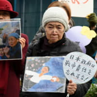 Supporters hold portraits of former \"comfort women\" during a protest at Japan\'s Foreign Ministry in Tokyo in 2016. | SATOKO KAWASAKI