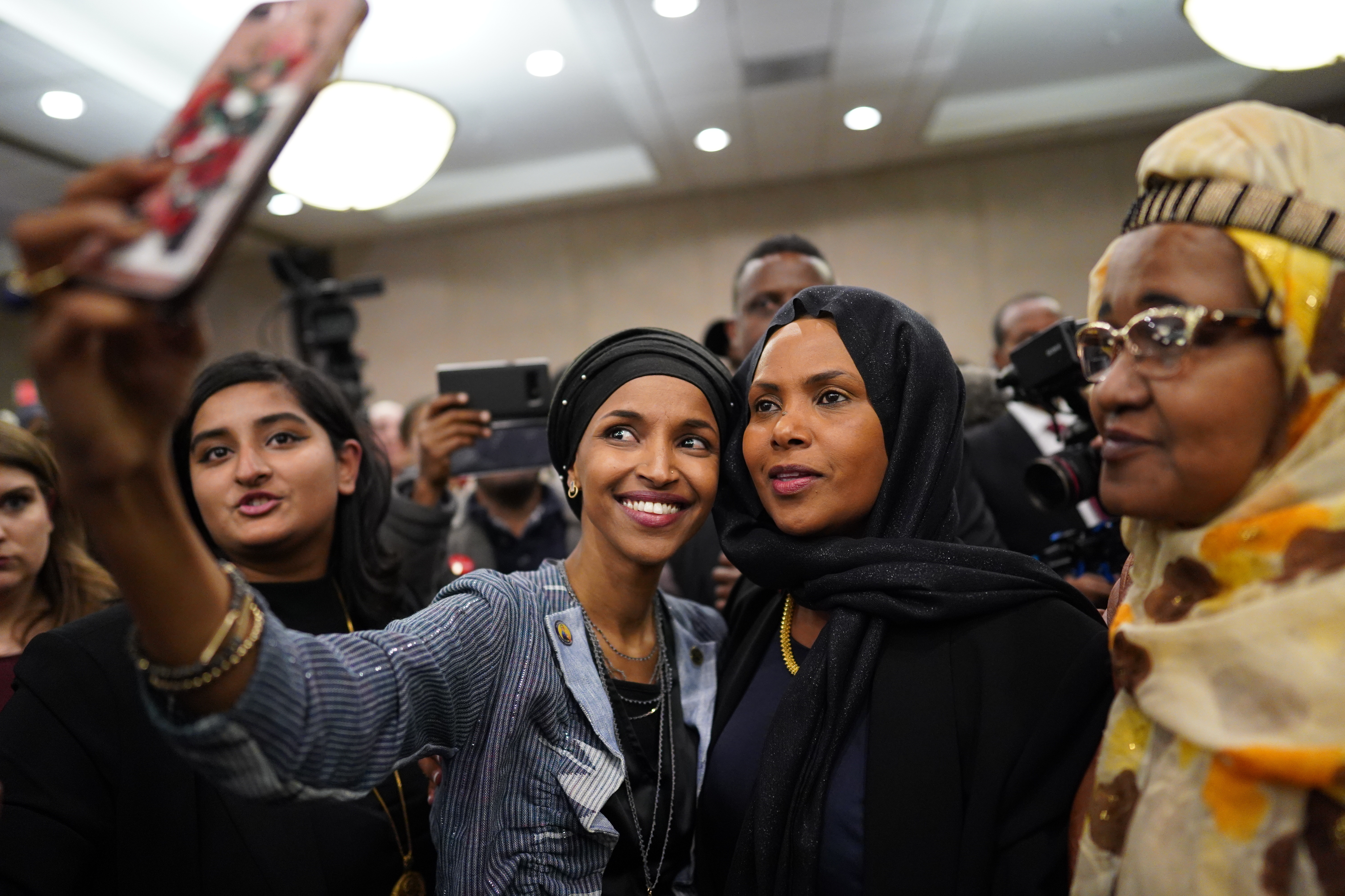 Ilhan Omar poses for a selfies with supporters after her victory Tuesday, in Minneapolis. Omar is poised to become the first Somali-American elected to Congress.
