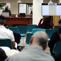 People attend a public auction where a letter written in 1922 by physicist Albert Einstein is put up for sale at Kedem Auction House in Jerusalem Tuesday. | REUTERS