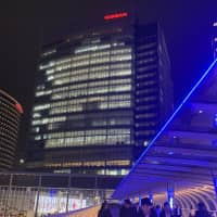 People walk outside Nissan headquarters in Yokohama on Monday. | MAGDALENA OSUMI