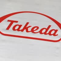 The logo of Takeda Pharmaceutical Co. is displayed at the company\'s news conference venue in Tokyo in May. | REUTERS