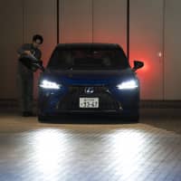 A staff member assists customers as they prepare to test-drive a Toyota Motor Corp. Lexus LS500 sedan parked at the Lexus Meets Hibiya showroom in Tokyo on Friday. | BLOOMBERG