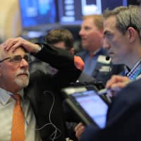 Traders react on the floor at the New York Stock Exchange (NYSE) in New York City Monday. | REUTERS