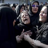 Families of victims of a terrorist attack on a military parade that killed 25 in the southwestern Iranian city of Ahvaz mourn at a mass funeral ceremony on Sept. 24. | AP