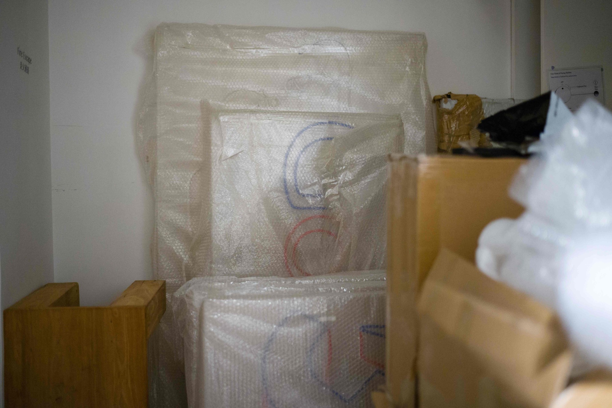 Wrapped artworks by Chinese political cartoonist Badiucao are seen after his first solo international exhibition 'Gongle' was cancelled in Hong Kong on Friday. | AFP-JIJI