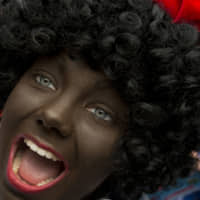A Black Pete meets children during the arrival of Sinterklaas in Maassluis, the Netherlands, on Nov. 12, 2016. | AP