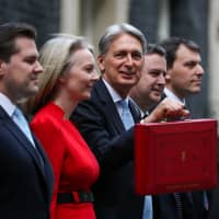 British financial services minister John Glen (right) and other financial officials pose for photographs outside No. 10 Downing St. in London on Oct. 29. | BLOOMBERG