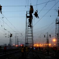 Workers are seen in silhouette at the Korla railway station under construction in Bayingolin Mongol Autonomous Prefecture, Xinjiang Uighur Autonomous Region, China, Oct. 31. | REUTERS