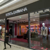 A woman walks out of a Dolce &amp; Gabbana outlet in Shanghai on Wednesday. | AP