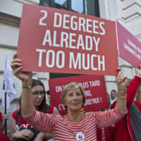 Demonstrators hold placards during n rally in Paris last month highlighting climate change. | AP