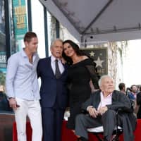 Actor Michael Douglas poses with his father, Kirk Douglas, wife Catherine Zeta-Jones and son Cameron Douglas during the unveiling of his star on the Hollywood Walk of Fame in Los Angeles Tuesday. | REUTERS