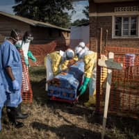 Medical workers disinfect the coffin of a deceased unconfirmed Ebola patient inside an Ebola Treatment Center run by The Alliance for International Medical Action (ALIMA) in August  in Beni, Congo. | AFP-JIJI