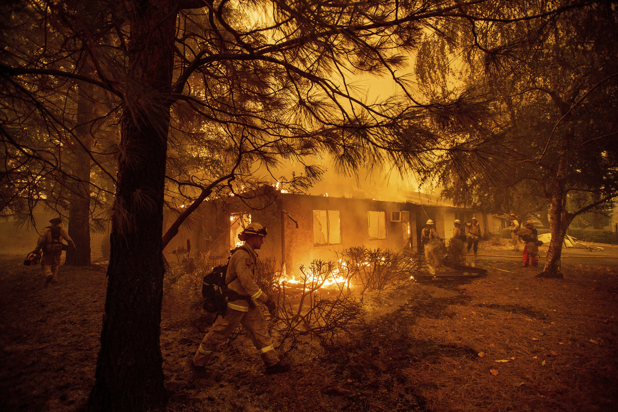 Firefighters work to keep flames from spreading through the Shadowbrook apartment complex in Paradise, California, last Friday. | AP
