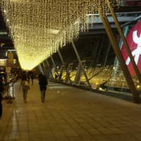 A couple walk past an MTR Corp. logo outside Hong Kong station on Saturday. The city\'s democratic opposition is aiming to win back a crucial legislative council seat in an election Sunday that would restore some of its veto power. | AFP-JIJI
