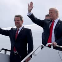 U.S. President Donald Trump and Republican candidate for Georgia governor Brian Kemp (left) arrive attend a campaign rally at Middle Georgia Regional Airport in Macon, Georgia, Sunday. | REUTERS