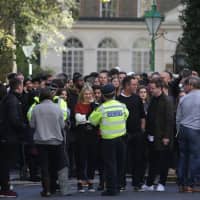 Staff evacuated from the office building housing Sony Music\'s offices are seen with police officers on a nearby street after an incident at the offices in London on Friday. | AFP-JIJI