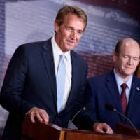 Sens. Jeff Flake (R-AZ) (left) and Christopher A. Coons (D-DE) hold a press conference on legislation to protect the Mueller Investigation on Capitol Hill Wednesday in Washington. | AFP-JIJI