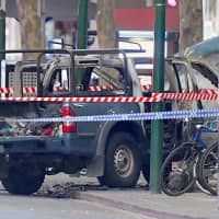 A burnt out vehicle is surrounded by police tape on Bourke Street in central Melbourne, Australia, on Friday. | AAP / VIA REUTERS