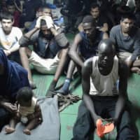 Migrants on board the containership Nivin are refusing to disembark in Misrata, Libya, Nov. 14. A total of 91 migrants, including a baby, were rescued by the ship\'s crew after leaving Libya in a raft. | AP