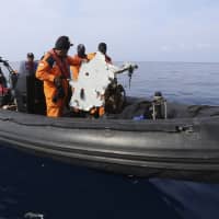Rescuers recover a piece of airplane part from Lion Air flight 610 that crashed into the sea during a rescue operation in the waters of Tanjung Karawang, Indonesia, Oct. 29. | AP