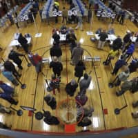 Voters wait in line in the gymnasium at Brunswick Junior High School to receive their ballots for the midterm election Tuesday in Brunswick, Maine. | AP