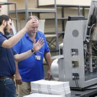 Employees at the Broward County Supervisor of Elections office check a machine as they sort ballots before being counted Monday in Lauderhill, Florida. | AP