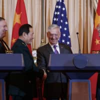 U.S. Secretary of State Mike Pompeo, Chinese Defense Minister Gen. Wei Fenghe (second from left), U.S. Secretary of Defense Jim Mattis and Chinese Politburo member Yang Jiechi shake hands at the conclusion of a news conference at the State Department in Washington on Friday. | AP