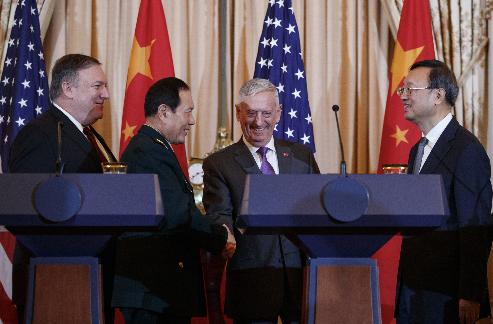 U.S. Secretary of State Mike Pompeo, Chinese Defense Minister Gen. Wei Fenghe (second from left), U.S. Secretary of Defense Jim Mattis and Chinese Politburo member Yang Jiechi shake hands at the conclusion of a news conference at the State Department in Washington on Friday. | AP